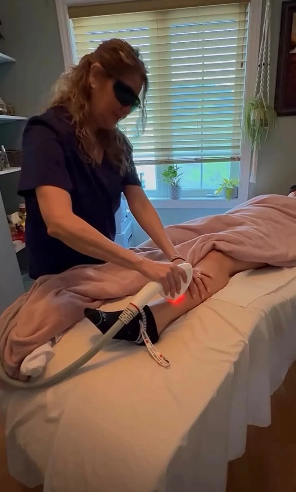 TBM Glow Lab team performing a laser hair removal treatment on a client’s leg